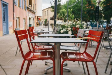 Temalı kafe ve restoranlar. Fransa 'da Avrupa' daki sokak kafeteryalarının parlak renklerinden oluşan dış yaz terası. Masaları korudum. İnsanlar olmadan, masalarda kimse olmadan..