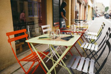 Temalı kafe ve restoranlar. Fransa 'da Avrupa' daki sokak kafeteryalarının parlak renklerinden oluşan dış yaz terası. Masaları korudum. İnsanlar olmadan, masalarda kimse olmadan..