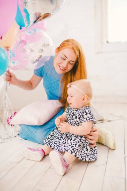 Hava ile şişirilen balonlar çok onun elinde tutan bir elbise parlak bir oturma odasında bir evde katında oturan bir çocuk tatil ağlayan bir çocuk anne yatıştırır.