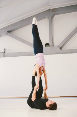 paspaslar üzerinde beyaz bir spor salonunda akrobatik yoga uygulamak Genç beyaz erkek ve kadın bir çift. Mill, konum türü L-Bass, zorluk gerçekten zor kişi 2 kişi sayısı becerileri Loy el, Rüzgar.