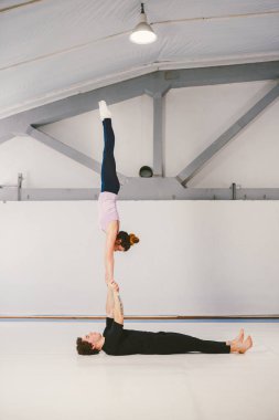 paspaslar üzerinde beyaz bir spor salonunda akrobatik yoga uygulamak Genç beyaz erkek ve kadın bir çift. Mill, konum türü L-Bass, zorluk gerçekten zor kişi 2 kişi sayısı becerileri Loy el, Rüzgar.