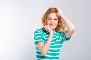 Mavi gri bir arka plan üzerinde stüdyoda şeritler ile yakın çekim portre bir yazlık elbise kırmızı kıvırcık saçlı genç, güzel bir kadının. Yaz tatil, turizm ve yaz giysileri Tema