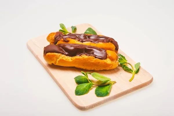 Eclairs Placă Masă Fundal Luminos Tort Cremă Eclair Ciocolată Desert — Fotografie de stoc gratuită