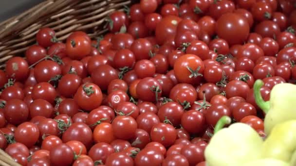 Thème santé et aliments naturels. Gros plan de la main d'un homme caucasien tenant, cueillant des tomates dans une vtrine dans une boîte de supermarché. Végétarien gars achète des légumes rouges 