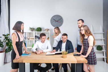 İş ve ekip çalışması temasıdır. İşçilerin bir grup brifing, çalışma kağıtları ve ahşap bir masa etrafında ışık Office belgeleri ile bir toplantı, Genç beyaz insanlar office.