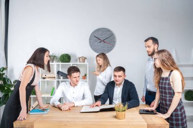 İş ve ekip çalışması temasıdır. İşçilerin bir grup brifing, çalışma kağıtları ve ahşap bir masa etrafında ışık Office belgeleri ile bir toplantı, Genç beyaz insanlar office.