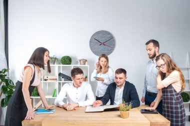 İş ve ekip çalışması temasıdır. İşçilerin bir grup brifing, çalışma kağıtları ve ahşap bir masa etrafında ışık Office belgeleri ile bir toplantı, Genç beyaz insanlar office.