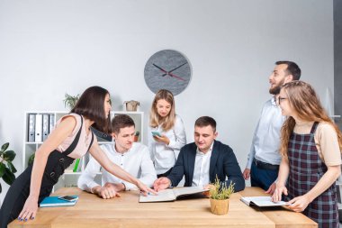 İş ve ekip çalışması temasıdır. İşçilerin bir grup brifing, çalışma kağıtları ve ahşap bir masa etrafında ışık Office belgeleri ile bir toplantı, Genç beyaz insanlar office.