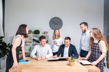 İş ve ekip çalışması temasıdır. İşçilerin bir grup brifing, çalışma kağıtları ve ahşap bir masa etrafında ışık Office belgeleri ile bir toplantı, Genç beyaz insanlar office.