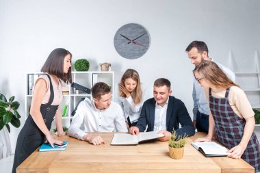 İş ve ekip çalışması temasıdır. İşçilerin bir grup brifing, çalışma kağıtları ve ahşap bir masa etrafında ışık Office belgeleri ile bir toplantı, Genç beyaz insanlar office.
