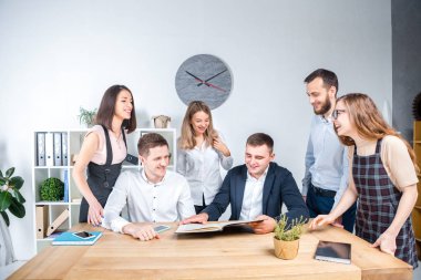 İş ve ekip çalışması temasıdır. İşçilerin bir grup brifing, çalışma kağıtları ve ahşap bir masa etrafında ışık Office belgeleri ile bir toplantı, Genç beyaz insanlar office.