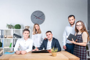 İş ve ekip çalışması temasıdır. İşçilerin bir grup brifing, çalışma kağıtları ve ahşap bir masa etrafında ışık Office belgeleri ile bir toplantı, Genç beyaz insanlar office.