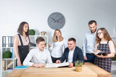 İş ve ekip çalışması temasıdır. İşçilerin bir grup brifing, çalışma kağıtları ve ahşap bir masa etrafında ışık Office belgeleri ile bir toplantı, Genç beyaz insanlar office.