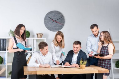 İş ve ekip çalışması temasıdır. İşçilerin bir grup brifing, çalışma kağıtları ve ahşap bir masa etrafında ışık Office belgeleri ile bir toplantı, Genç beyaz insanlar office.