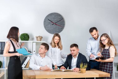İş ve ekip çalışması temasıdır. İşçilerin bir grup brifing, çalışma kağıtları ve ahşap bir masa etrafında ışık Office belgeleri ile bir toplantı, Genç beyaz insanlar office.
