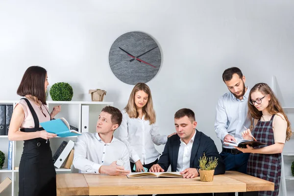 İş ve ekip çalışması temasıdır. İşçilerin bir grup brifing, çalışma kağıtları ve ahşap bir masa etrafında ışık Office belgeleri ile bir toplantı, Genç beyaz insanlar office.