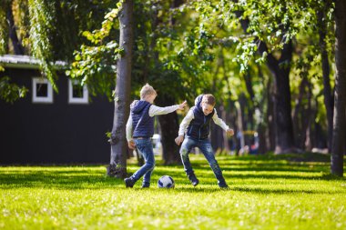 Tema aile açık hava etkinlikleri. altı anne baba büyük dostu beyaz ailesi ve dört çocuk futbol topu ile çim üzerinde çalışan, güneşli bir günde evin yanında çim çim yeşil.
