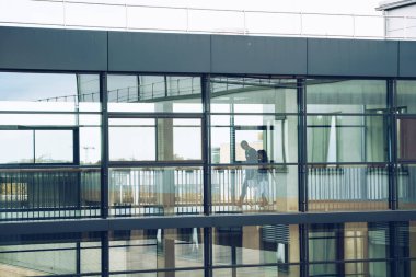 22 Ekim 2018. Almanya Helios Klinikum Krefeld. Siluet Doktor Doktor insanlar erkek ve Kadın Kliniği kat görünümünde pencereden istasyonları arasında koridoru geç taşıma yürümek.