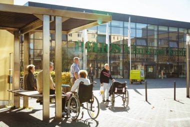 Ekim 2018. Helios Klinikum Krefeld, Almanya. Hastane girişinde bir parkı bir meydanda emekliler tekerlekli sandalye içinde bir grup aittir. Tema sosyal yaşlılar devlet kliniği.