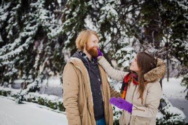 Sakalı ve bir kız Genç bir beyaz çocuk var kendini ve kış oyunları oynamak bir tarihi açık havada kış parkta bir karlı kozalaklı ağaç oyun kartopu, atmak kar, arka planı.