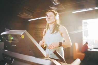 Spor ve müzik temasıdır. Güzel bir şişirilmiş kadın spor salonunda bir koşu bandı üzerinde çalışır. Kafasında büyük beyaz kulaklık, kilo kaybı için bir kardiyo egzersiz sırasında kız müzik dinliyor.