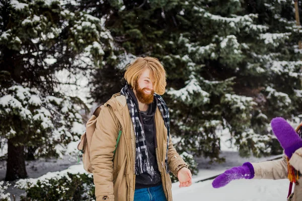 겨울에는 날짜입니다 남자는 수염과 머리는 여자와 눈덩이 장난으로 숲에서 발렌타인 — 스톡 사진