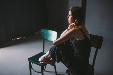 Sosyal Tema kadın yalnızlık acı acı. Abastration erkek şiddet aile. Büyük karanlık odada üç sandalyelere oturan siyah giysili genç güzel beyaz kadın. Srach ve umutsuzluk.