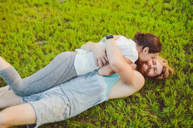 Spor ve sağlıklı bir yaşam tarzı temasıdır. Bir genç adam ve kadın çift spor oynadıktan sonra sırtlarını yeşil çimenlerin üzerinde bir paket içinde bir çim yatan dinlenme. Ailenin ortak eğitim.