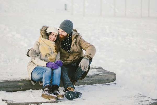 在圣诞节的冬天 一个有胡子的男人和一个白人妇女坐在木楼梯上 一个与圣诞节拥抱的约会 — 图库照片