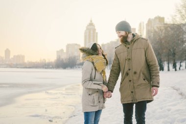 Tema Noel tatil kış yeni yıl. Seven çift genç şık beyaz donmuş bir gölün kıyısında yürüyüş Heteresexual. Tarih. Sevgililer günü gün batımında kışın. Aşk ve romantizm Tema.