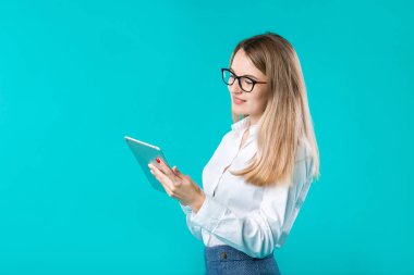 Portre genç kafkas kadın işçi öğretmen eğitmen el Beyaz gömlek office tarzı uzun saç bir tablet ile rehberlik izole teknoloji parlak renk mavi arka plan kullanır.