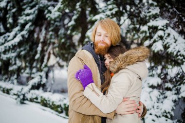 aşk tema kış Sevgililer günü olduğunu. Güzel genç Kafkas çift heteroseksüel sarılma kış kar frost mutluluk tarih ve parkta bir arka plan karlı ağaçları seviyorum.