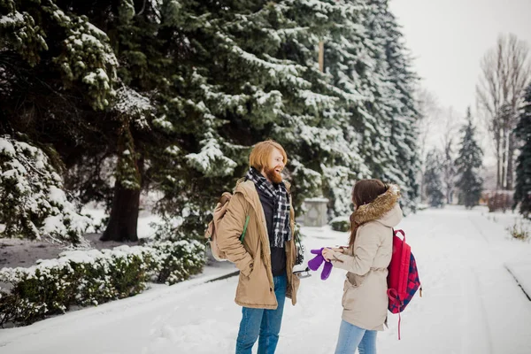 Happy couple playful together during winter holidays vacation outside in snow park.