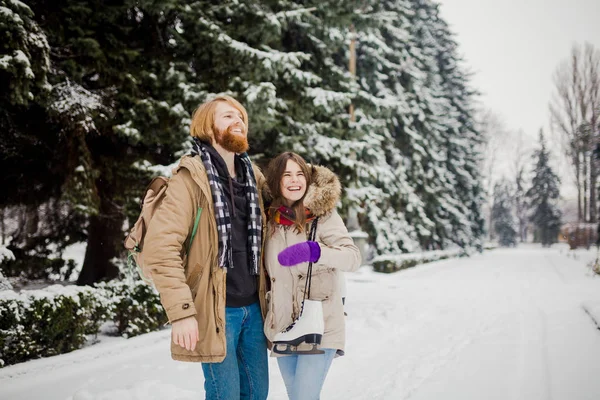 Güzel genç beyaz insanlar aşık bir tarihte kış Park'ta bir çift gördüm. Bir adam bir sakal, paten ve bir sırt çantası ile hugs, bir adam, bir kadın bir tarih Sevgililer günü doğada seviyor.