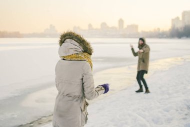 Genç Kafkas aşıklar heteroseksüel çift kış bir tarihi olan donmuş bir gölün yakınında. Aktif tatil tatil Valentine's Day, kartopu oynarken ve sevinç oynamak.