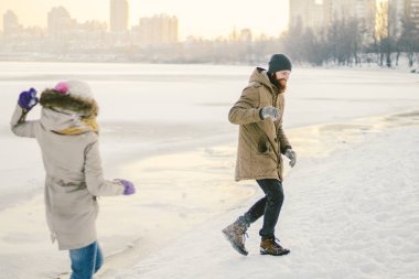 Genç Kafkas aşıklar heteroseksüel çift kış bir tarihi olan donmuş bir gölün yakınında. Aktif tatil tatil Valentine's Day, kartopu oynarken ve sevinç oynamak.