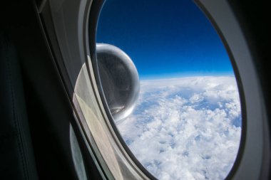 Uçağın kanat üzerine pencere ve motorları fokker 100 model mavi bir gökyüzü ve beyaz bulutlar ile görüntüleyin. Güneşli havalarda.