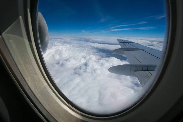 从飞机的窗口可以看到一个蓝色天空和白云的 Fokker 100 模型的机翼和发动机 — 图库照片