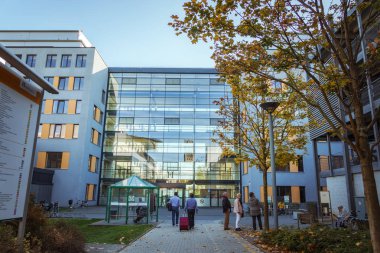 October 21, 2018. Germany, Krefeld. Entrance to Crefeld clinic in Helios, near the city of Dusseldorf. Modern European hospital. A male patient goes back with a suitcase for planned hospitalization.