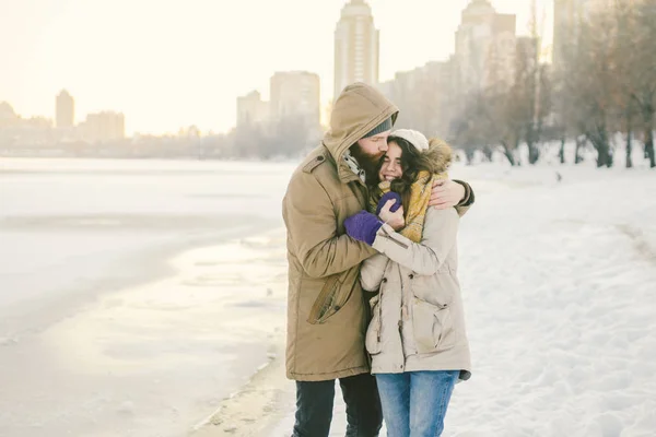 主题爱情和自然约会 一个年轻的高加索异性恋夫妇和女孩走在冬季沿着冰湖在冬季 带着胡子的男人抱着女人 情人节假期 — 图库照片
