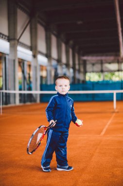 20 Eylül 2016. Ukrayna, Kiev.theme fiziksel gelişim çocuk. Çocuk Çocuk 3 - 4 yıl eski pozlar Tenis raket topu ile el tenis portakal kabuğu arka plan tnet içinde mavi spor takım.