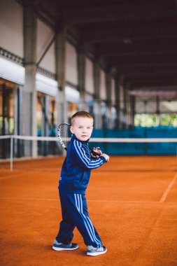 20 Eylül 2016. Ukrayna, Kiev.theme fiziksel gelişim çocuk. Çocuk Çocuk 3 - 4 yıl eski pozlar Tenis raket topu ile el tenis portakal kabuğu arka plan tnet içinde mavi spor takım.