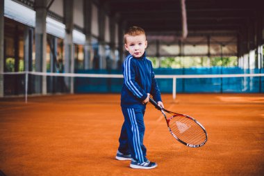20 Eylül 2016. Ukrayna, Kiev.theme fiziksel gelişim çocuk. Çocuk Çocuk 3 - 4 yıl eski pozlar Tenis raket topu ile el tenis portakal kabuğu arka plan tnet içinde mavi spor takım.