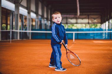 20 Eylül 2016. Ukrayna, Kiev.theme fiziksel gelişim çocuk. Çocuk Çocuk 3 - 4 yıl eski pozlar Tenis raket topu ile el tenis portakal kabuğu arka plan tnet içinde mavi spor takım.