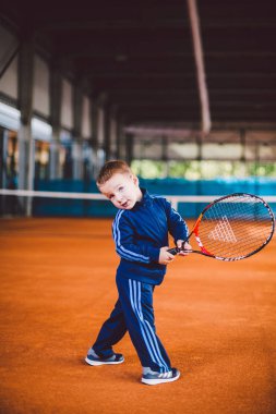 20 Eylül 2016. Ukrayna, Kiev.theme fiziksel gelişim çocuk. Çocuk Çocuk 3 - 4 yıl eski pozlar Tenis raket topu ile el tenis portakal kabuğu arka plan tnet içinde mavi spor takım.