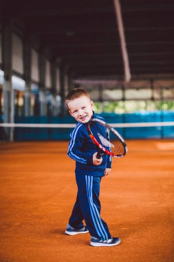 20 Eylül 2016. Ukrayna, Kiev.theme fiziksel gelişim çocuk. Çocuk Çocuk 3 - 4 yıl eski pozlar Tenis raket topu ile el tenis portakal kabuğu arka plan tnet içinde mavi spor takım.