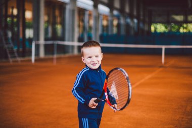 20 Eylül 2016. Ukrayna, Kiev.theme fiziksel gelişim çocuk. Çocuk Çocuk 3 - 4 yıl eski pozlar Tenis raket topu ile el tenis portakal kabuğu arka plan tnet içinde mavi spor takım.