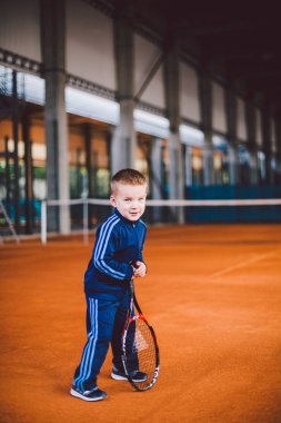 20 Eylül 2016. Ukrayna, Kiev.theme fiziksel gelişim çocuk. Çocuk Çocuk 3 - 4 yıl eski pozlar Tenis raket topu ile el tenis portakal kabuğu arka plan tnet içinde mavi spor takım.