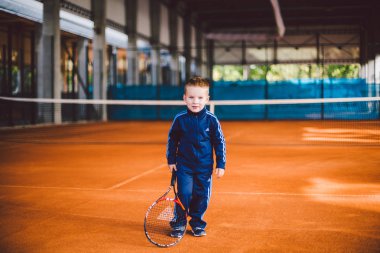 20 Eylül 2016. Ukrayna, Kiev.theme fiziksel gelişim çocuk. Çocuk Çocuk 3 - 4 yıl eski pozlar Tenis raket topu ile el tenis portakal kabuğu arka plan tnet içinde mavi spor takım.