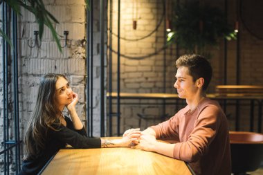 Tema aşk ve tatil Sevgililer günü. Üniversite öğrencileri birlikte beyaz heteroseksüel severler kış kafe içinde birkaç boş tablo kucaklama otur. Duygu mutluluk ve sevgi.